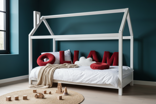 Rote Rainbow Letters im Hausbett